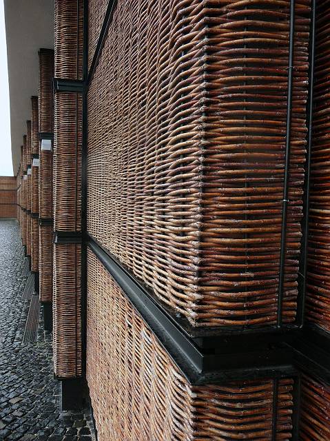 Facade of the garage of a fancy hotel constructed from steal and real bush-branches